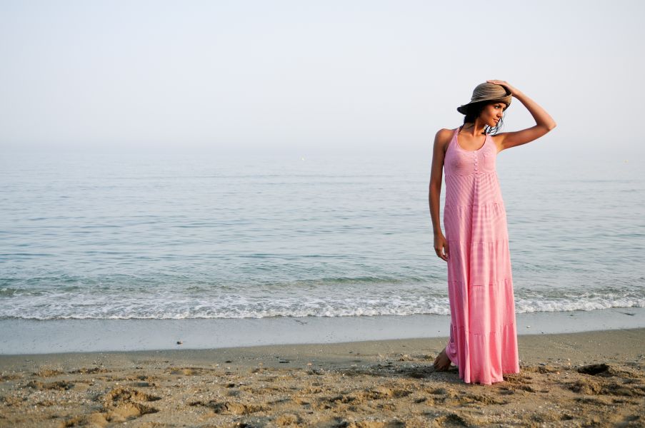 Kobieta w długiej sukience nad brzegiem morza